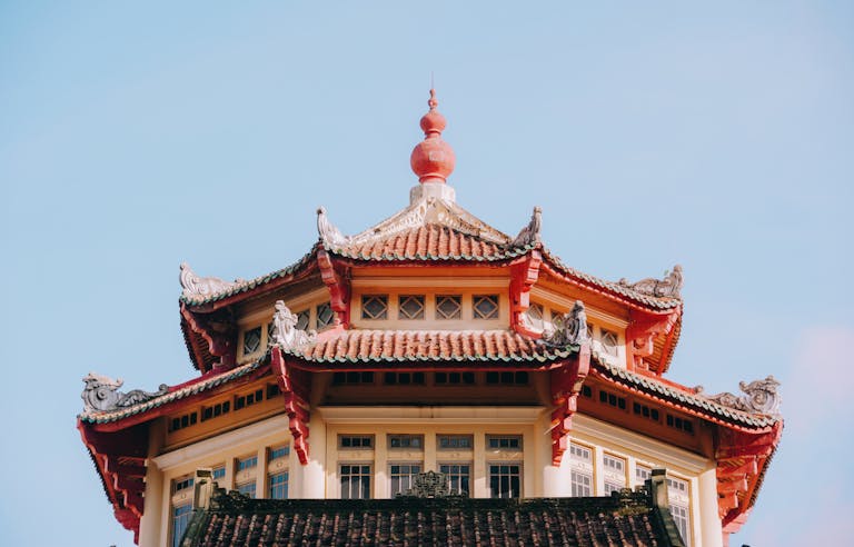 Close-up of a traditional Chinese pagoda roof showcasing intricate architectural details against a clear sky.