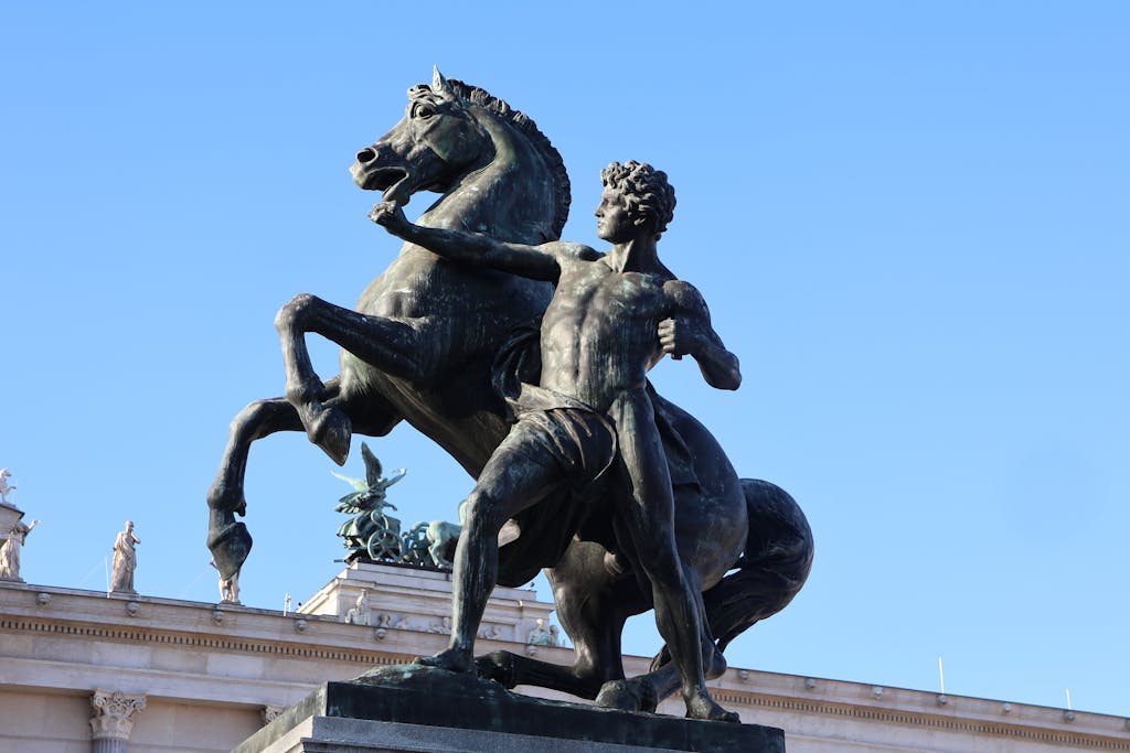 A striking equestrian statue at Hofburg Palace in Vienna, showcasing dynamic artistry against a clear sky.